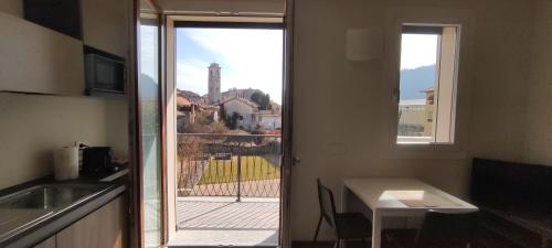 a kitchen with a door leading to a balcony with a view at Appartamenti Del Borgo in Borgosesia