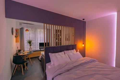 a purple bedroom with a bed and a desk at Tsimiski Contemporary Studio 2 in Thessaloniki