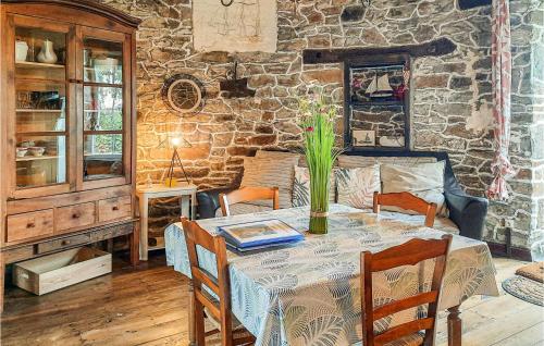 une salle à manger avec une table et un vase de fleurs. dans l'établissement Beautiful Home In Cherrueix, à Cherrueix