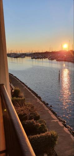 una vista de un cuerpo de agua al atardecer en bel appartement avec jolie vue sur l'eau, en Cap d'Agde