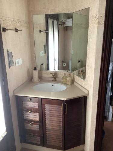 uma casa de banho com um lavatório e um espelho grande em El Aroma del Dulce em Setenil de las Bodegas
