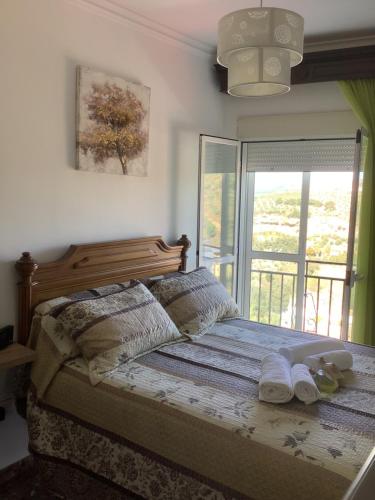 a bedroom with a bed with slippers on it at El Aroma del Dulce in Setenil