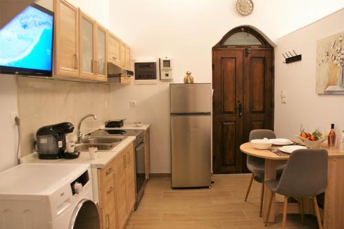 a kitchen with a sink and a refrigerator and a table at Evangelia's Little House in Rhodes Town