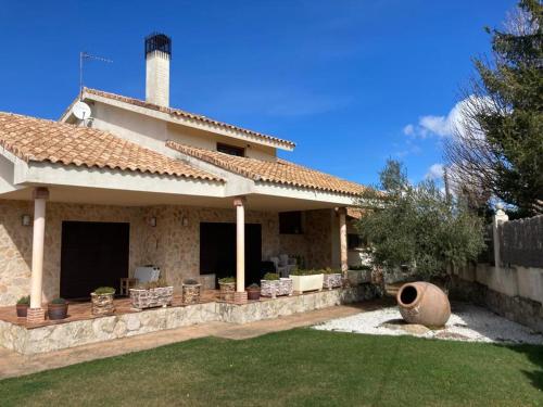 a house with a patio and a yard at Casa El Descanso Ortigosa del Monte in Ortigosa del Monte