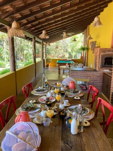een houten tafel met eten en drinken erop bij Pousada Jardim Boêmio in Cananéia