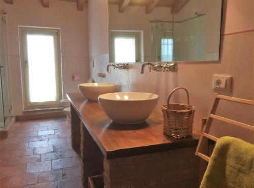 a bathroom with two sinks on a wooden counter at da Luigi al Mulino in Annicco