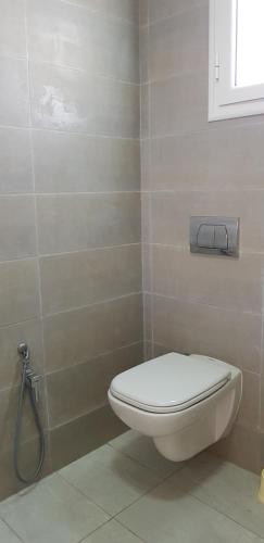 a bathroom with a white toilet and a window at Villa Aline Lagune Djerba in Midoun