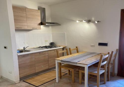 a kitchen with a table with chairs and a sink at CELESTE Central Apartment in Porto Rotondo with private parking in Porto Rotondo