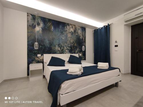 a bedroom with a bed with a painting on the wall at Tropea Travel's House in Tropea