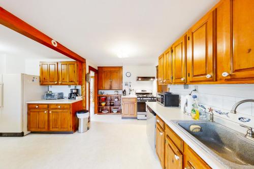 a kitchen with wooden cabinets and a sink at Murray Hill Waterside in East Boothbay
