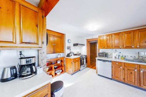 a kitchen with wooden cabinets and white appliances at Murray Hill Waterside in East Boothbay