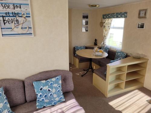 sala de estar con sofá y mesa en 341 Family Caravan at Marine Holiday Park, sleeps 6, en Rhyl