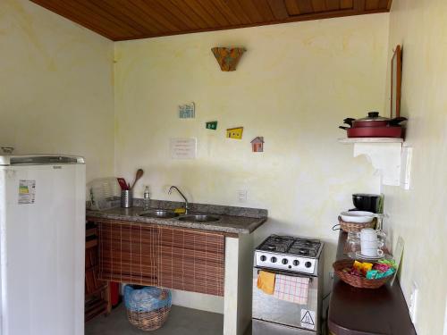 a small kitchen with a sink and a stove at Pousada Horizonte Azul in Ilha de Boipeba
