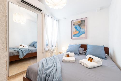 une chambre avec un lit bleu et un miroir dans l'établissement FEEL HOME - BARILLERIE, à Nice