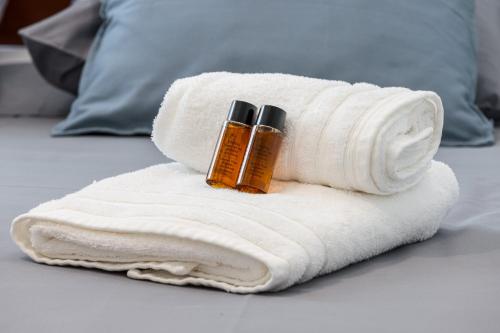 - une serviette avec 2 bouteilles d'huiles essentielles sur le lit dans l'établissement FEEL HOME - BARILLERIE, à Nice