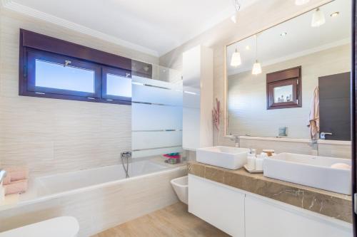 a bathroom with two sinks and a tub and a mirror at Cala Ratjada - 3818-01 Mallorca in Cala Ratjada