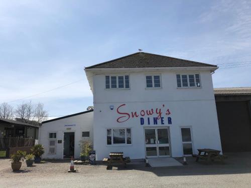 a white building with a sign on the side of it at G4 Holiday Caravan in Par