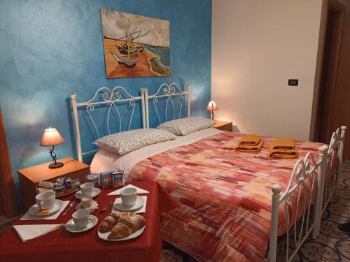 Palo del ColleにあるB&B Il Principeのベッドルーム1室(ベッド1台、テーブル、食べ物付)