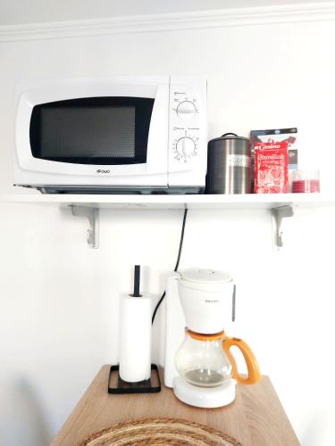 d'un four micro-ondes et d'une cafetière sur une étagère. dans l'établissement Quiet and cosy studio near Cattenom, Luxembourg and Metz, à Haute-Yutz