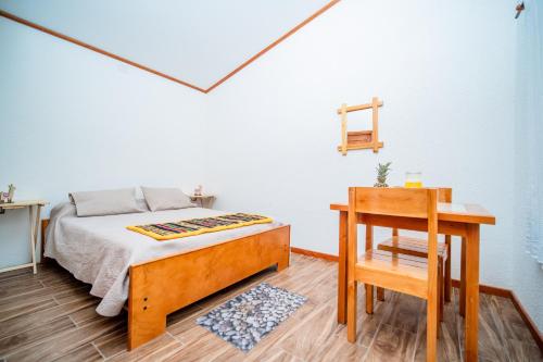a bedroom with a bed and a table and a desk at Tantakuy Eco Experience Hotel in La Huaica
