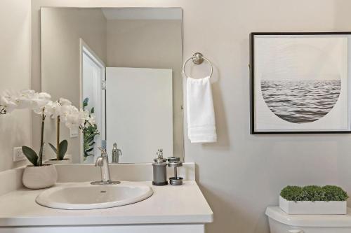 a white bathroom with a sink and a mirror at Splendid & Fully Furnished 1BR Apartment - Broadway 204 rep in Chicago