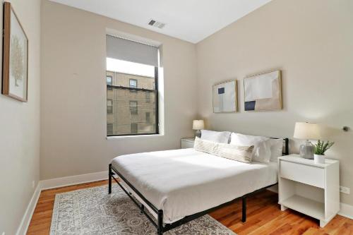 a white bedroom with a bed and a window at Splendid & Fully Furnished 1BR Apartment - Broadway 204 rep in Chicago