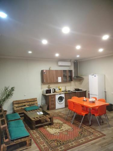 a living room with a table and a kitchen at Bee Lucky Hostel and Tours in Yerevan