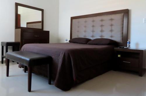 マサトランにあるDepartamento a 200 Mts de la playa y alberca en planta bajaの大きなベッドと鏡のある寝室