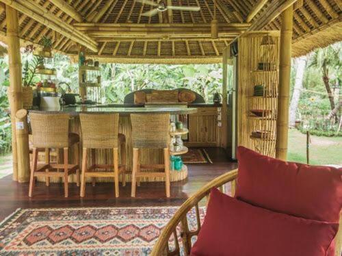 - une cuisine et une salle à manger avec une table et des chaises dans l'établissement Pondok Kebun - 1 bd Eco Bamboo House, Pool, Garden, à Bringkit