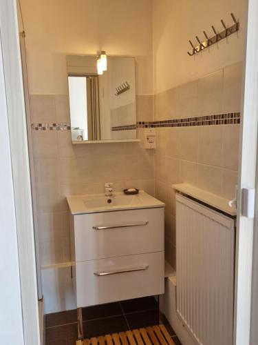 een badkamer met een wastafel en een spiegel bij Studio Malouin - Sur la digue de Malo les Bains avec vue sur mer in Malo-les-Bains