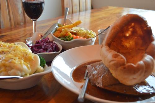 a table with a plate of food and a glass of wine at The Cornishman Inn in Tintagel