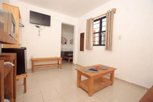 a living room with a table and a tv at Casa Amaiur in Huichapan