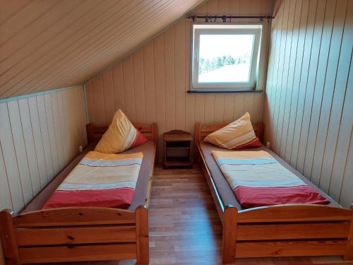 two beds in a small room with a window at AGROTURYSTYKA NAD STAWEM in Lichtenstein Ostpreussen
