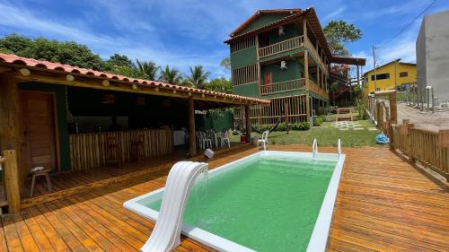 a house with a swimming pool on a wooden deck at Encanto do Mar Pousada in Caraíva
