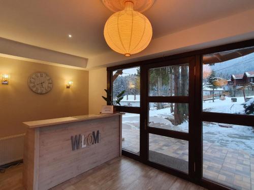 a lobby with a window and a clock on the wall at Vila PANORAMIC Busteni in Buşteni