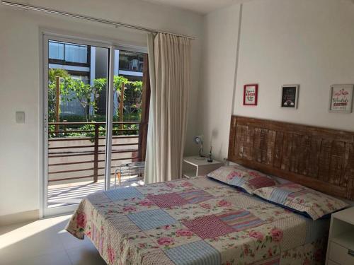 1 dormitorio con 1 cama y vistas a un balcón en Areias de Itacimirim 104 Village - Pé na Areia en Itacimirim