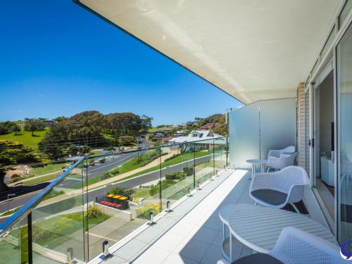 a balcony with chairs and a view of a street at Sapphire Waters Unit 3 in Narooma