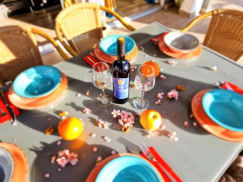 a table with a bottle of wine and glasses on it at Holiday house Boost with heated pool in Klis