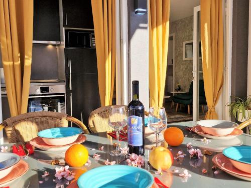 a table with a bottle of wine and glasses on it at Holiday house Boost with heated pool in Klis