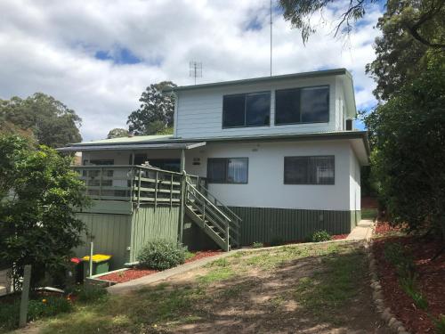 a house with a green and white at Metung Getaway in Metung