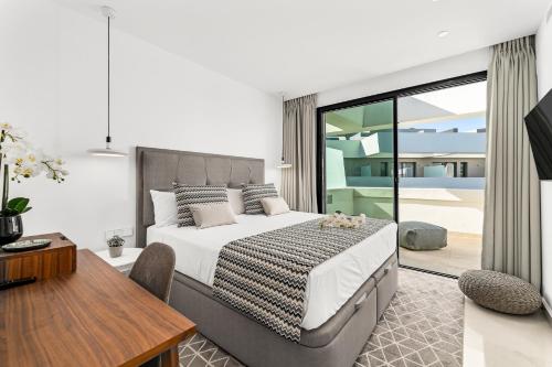 a bedroom with a bed and a table and a desk at Oasis by the Sea in La Cala de Mijas (La Valvega) in Mijas Costa