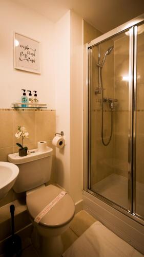 a bathroom with a shower and a toilet and a sink at High Street - 2BD Apt - King Beds - Parking - Wise Stays in Southampton