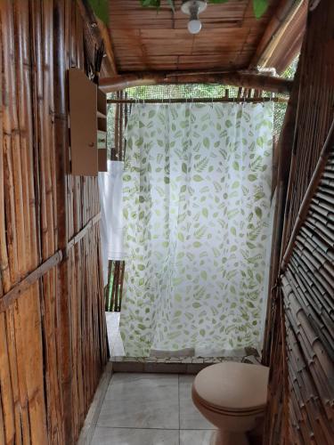 a bathroom with a toilet and a shower curtain at Cabañas Camino al Agua - Cocorná in San Francisco