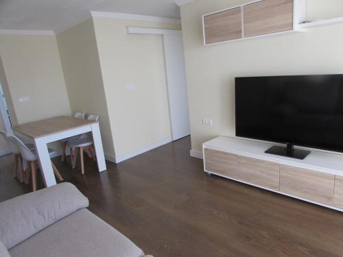 a living room with a large flat screen tv at Luz y Mar Huelva-Ático in Huelva