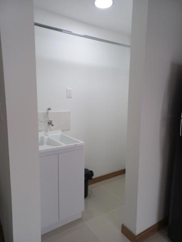 baño con lavabo y pared blanca en Apartamento FL Martinz, en Manizales