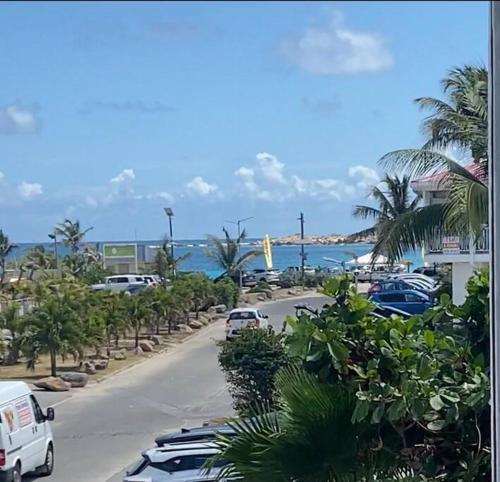 a street with cars parked in a parking lot near the ocean at One bedroom Duplex TIT’ HOME Orient bay in Orient Bay
