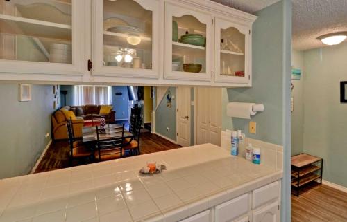 een keuken met witte kasten en een woonkamer bij DOLPHIN 23 condo in South Padre Island