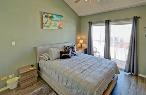 1 dormitorio con cama y ventana grande en DOLPHIN 23 condo, en South Padre Island