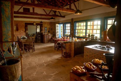 Casarão Milho Verde في ميلهو فيردا: مطبخ كبير فيه طاولة وكراسي