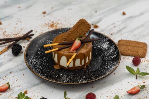 a chocolate dessert on a black plate on a table at Veliton Hotel in Al Khobar